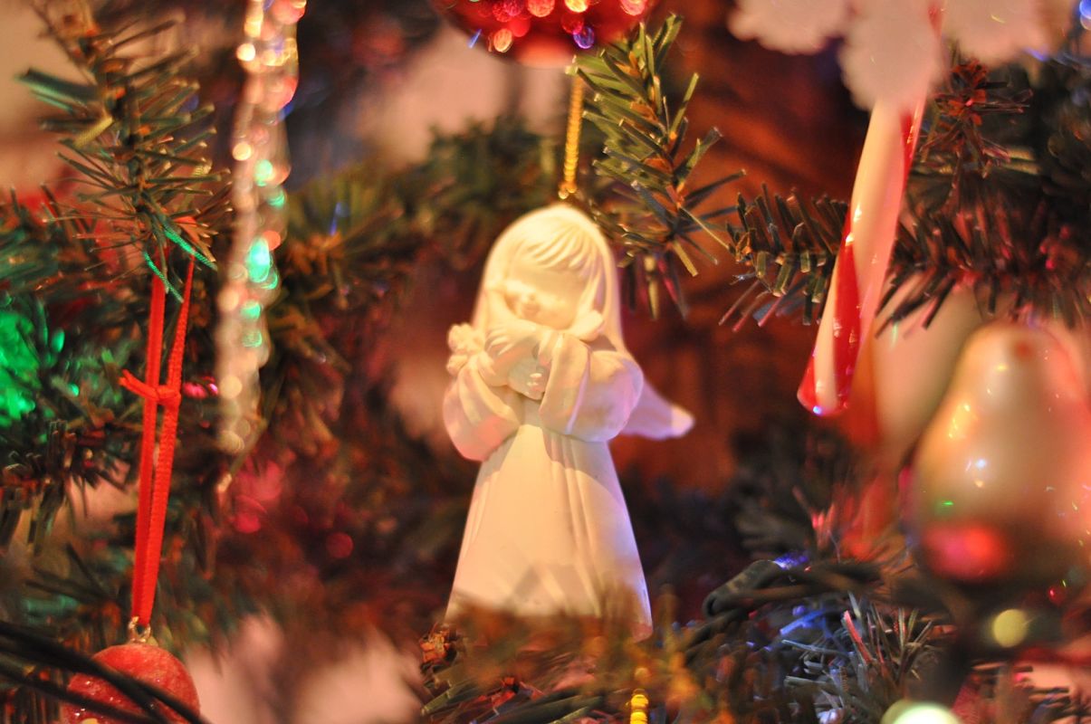 Un ángel con un árbol navideño de fondo