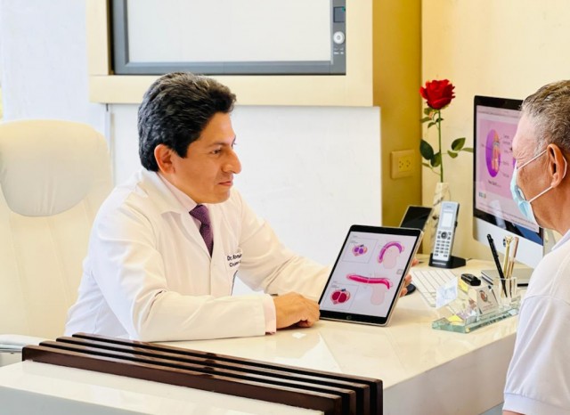 El urólogo Román Reyes Mazzini muestra con una tablet los problemas de disfunción eréctil a un hombre mayor.
