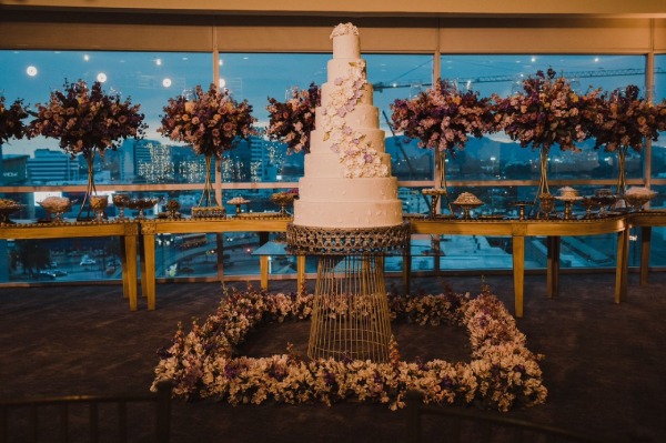 Torta blanca de novia con 8 pisos, dulces y arreglos florales en la fiesta de matrimonio de Daniel Calderón y Rossy Sornoza.