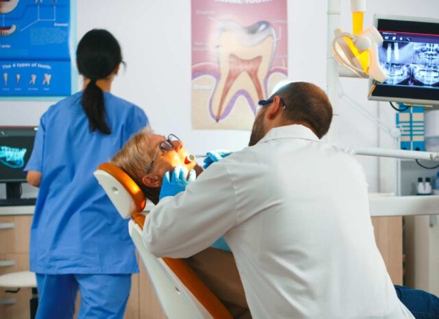 Dentista revisa dientes a mujer en consultorio dental