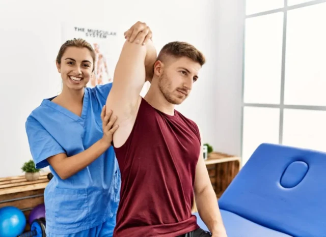 Fisioterapeuta hace tratamiento de rehabilitacion física del brazo derecho para aliviar el dolor y mejorar la movilidad.
