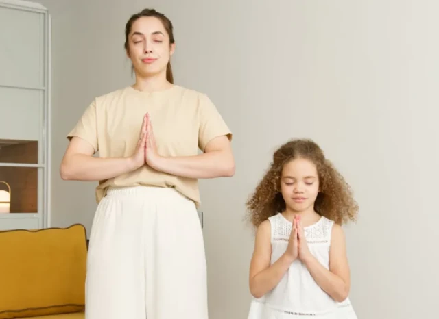 Madre e hija orando juntas como ejemplo de la importancia de iniciar la educación en la fe desde la infancia.