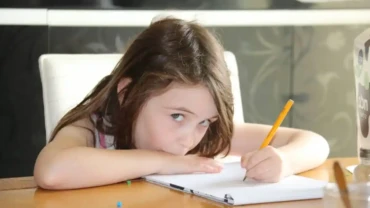 Niña con dificultades de concentración estudiando debido a trastornos de aprendizaje.
