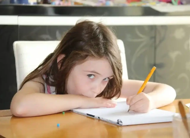 Niña con dificultades de concentración estudiando debido a trastornos de aprendizaje.