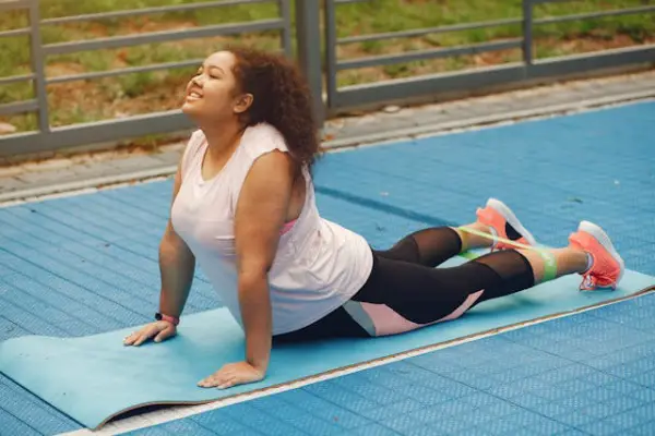 Mujer haciendo yoga al aire libre con banda de resistencia. 