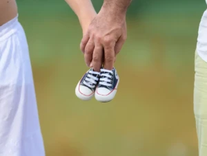 Pareja sosteniendo zapatos de bebé tras diagnóstico de útero subsepto parcial.