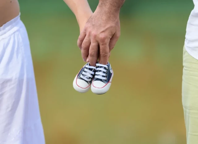 Pareja sosteniendo zapatos de bebé tras diagnóstico de útero subsepto parcial.