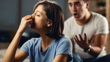 Pareja con señales de estrés y tensión conversando en casa.