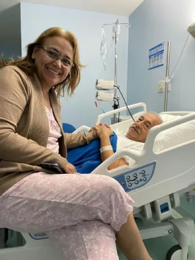 Carmen Zea sonriendo mientras sostiene la mano de Amalio Martínez en el hospital Alcívar.