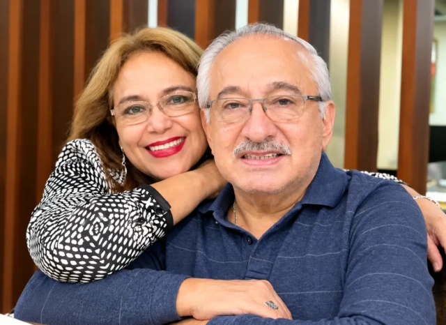 Carmen Zea Montoya, con blusa de punto en blanco y negro y labial rojo, inclinada cariñosamente junto a Amalio Martínez, con polo azul.